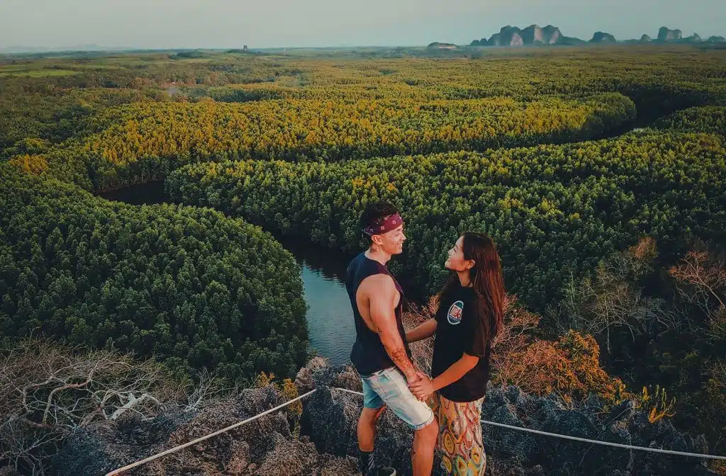 Flora and Note standing on top of a cliff overlooking a river.