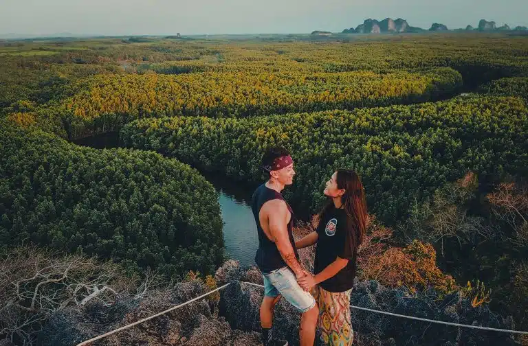 Flora and Note standing on top of a cliff overlooking a river.